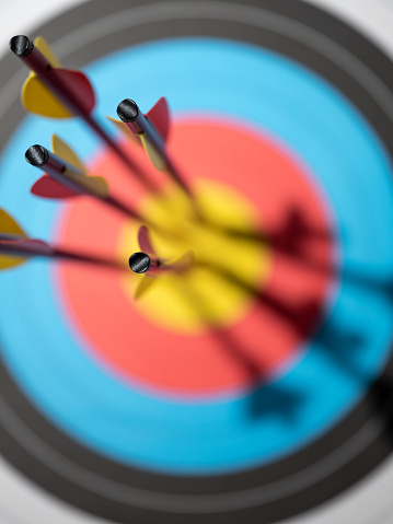 Five arrows in the bull's-eye of an archery target.  Concept image of being on target, strategy, aim, accomplishment, aiming for the bull's eye, etc.