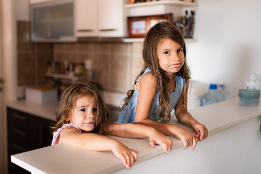 Sad girls in kitchen.