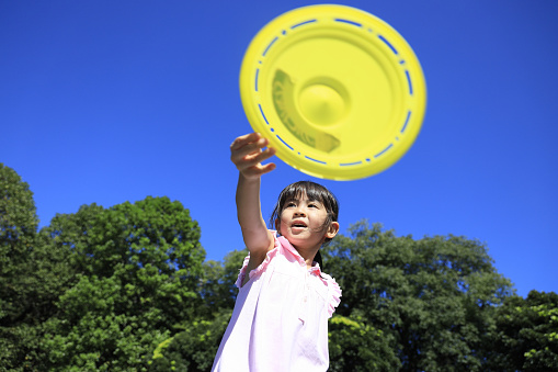 Japanese student girl playing flying disc (6 years old)