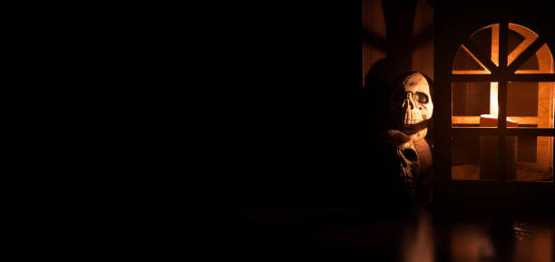 A human skull in an abandoned room in candlelight.