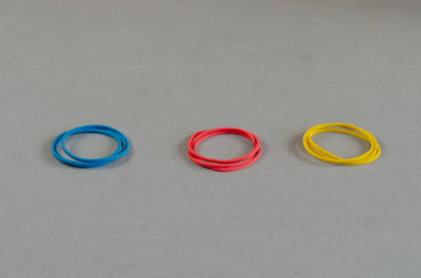 istock Three groups of stationery rubber bands on a gray background. Mu 1349178475