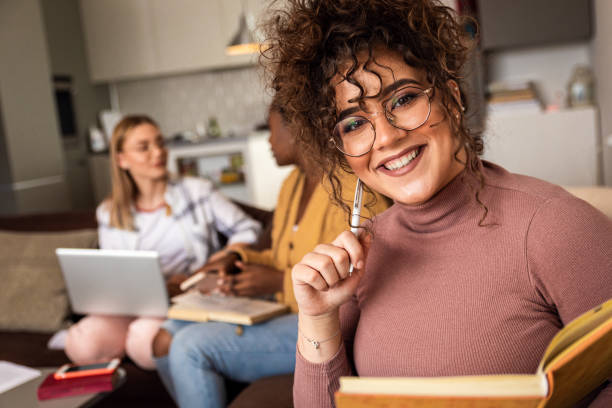 istock Multiethnic female students learning at home using laptop and books for research. 1349178689