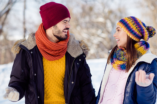 Photo portrait of cheerful couple walking together talking communicating in winter park