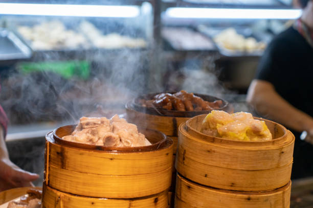 dampfendes kantonesisches dim sum ist in der küche - bamboo brown cooking gourmet stock-fotos und bilder