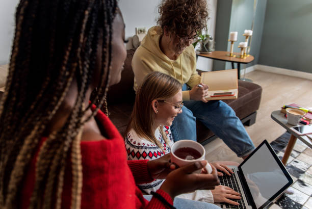 istock Multiethnic female students learning at home using laptop and books for research. 1349180275