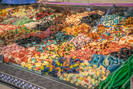 Assortment of gummy candies and sweets in the stall. Assorted colorful different shape jelly candies on the market.