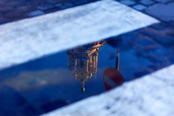 Pool on the street with church reflection . reflected road sign in the street water  . Wet asphalt in the city after the rain