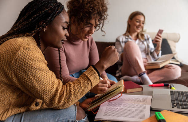 istock Multiethnic female students learning at home using laptop and books for research. 1349182409