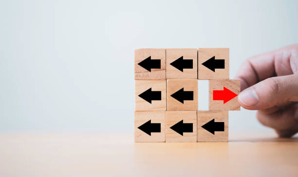istock Hand pull out red arrow red arrow which print screen on wooden cube block and opposite direction with black arrow , Business and technology disruption concept. 1349185537