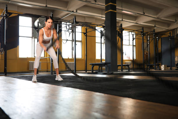 istock Fit woman using battle ropes during strength training at the gym. 1349186263