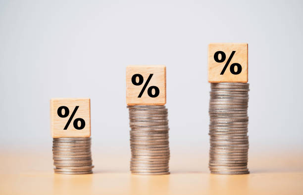 Percentage sign print screen on wooden cube block which lay down on increasing coins stacking for interest rate and business profit growth concept.