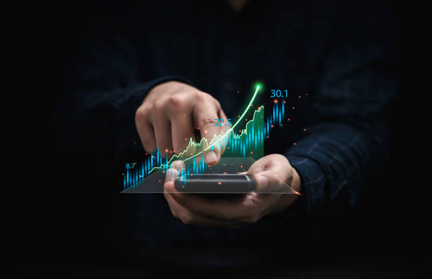 istock Trader holding smartphone and touching to technical graph chart  for analysis stock market data and speculator investment concept. 1349188454