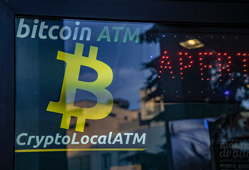 ROVIGO, ITALY 26 OCTOBER 2021: Bitcoin ATM Sign detail in a shop door. Close up photo of Bitcoin ATM sign, used for buying and selling cryptocurrencies