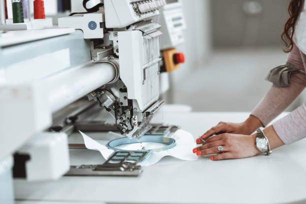 istock Female Textile Factory Worker Using Precise Coloring Machine For New Clothing Line 1349189034