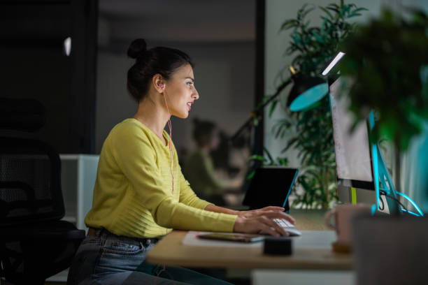 istock Woman working on computer in office at night 1349189886