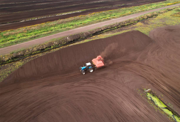istock Peat Harvester Tractor on Collecting Extracting Peat. Mining and harvesting peatland. 1349191420