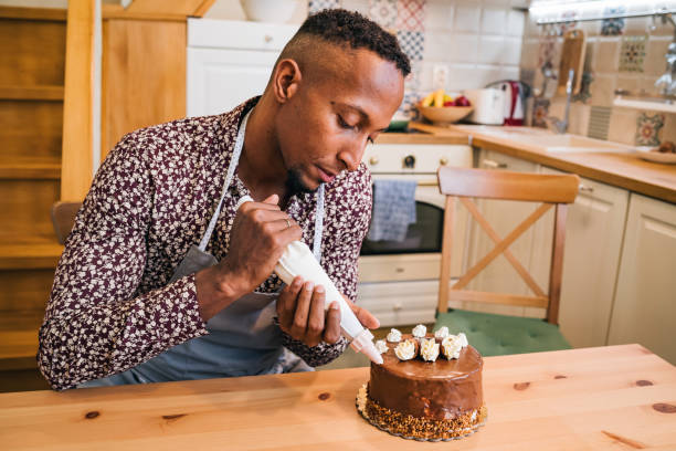istock Brazilian man decorating a cake at home 1349191943