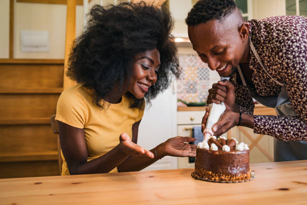istock Couple in love decorating a cake at home 1349191948
