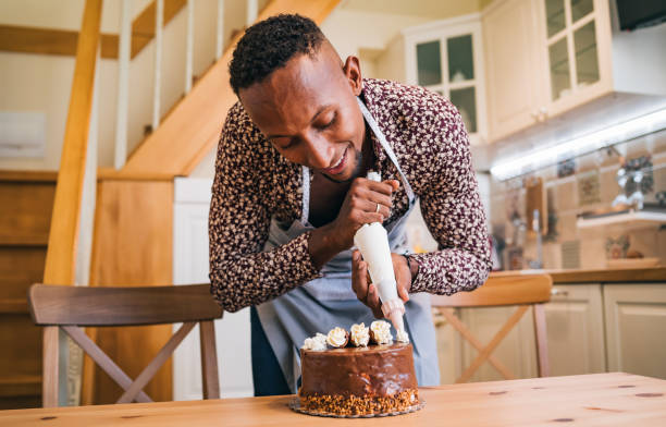 istock Brazilian man decorating a cake at home 1349191962