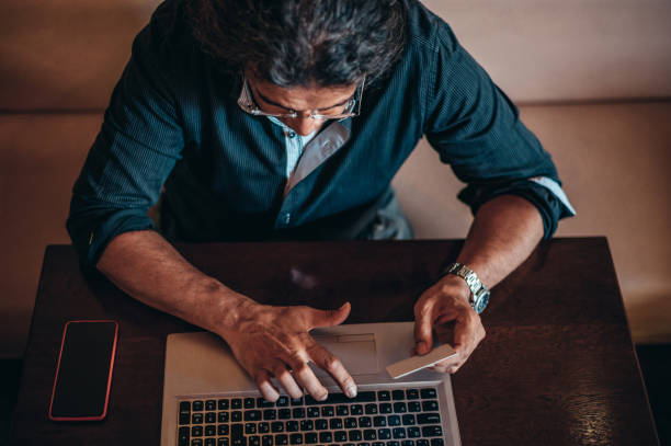 istock Senior hispanic cuban men using laptop and a credit card while online shopping 1349192848