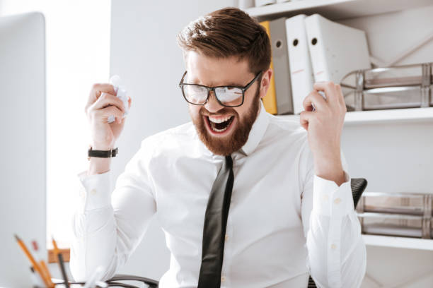 istock Angry young businessman holding documents. 1349192856