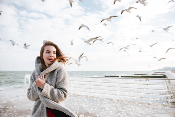 istock Smiling woman standing on pier in winter 1349193672