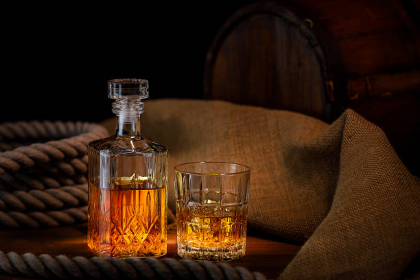 bicchiere e bottiglia di whisky su sfondo rustico - whisky alcohol pouring glass foto e immagini stock
