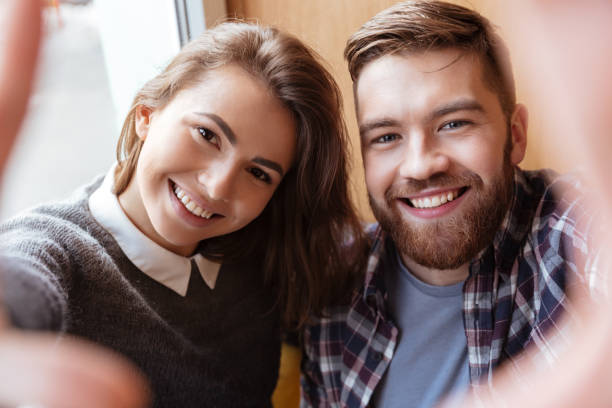 istock Handsome man and beautiful girl making selfie by the window 1349198888