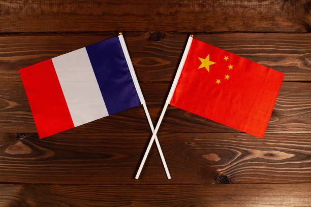 bandera de francia y bandera de china cruzadas entre sí. la imagen ilustra la relación entre los países. fotografía para noticias en video en tv y artículos en internet y medios de comunicación. - president of france fotografías e imágenes de stock