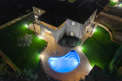 Luxurious beautiful modern villa with swimming pools and yard garden, aerial view by night, Istria, Croatia