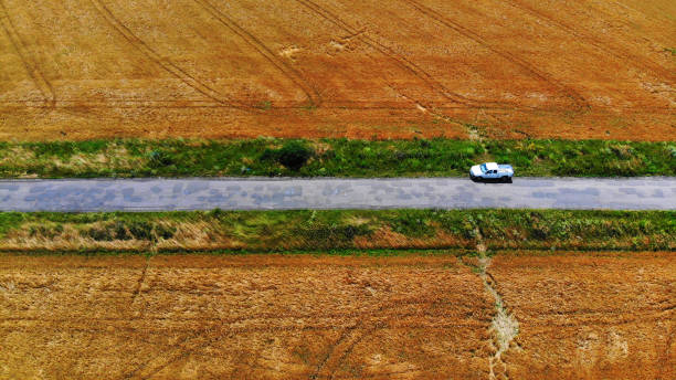 empty country road with wheat field background and blue sky