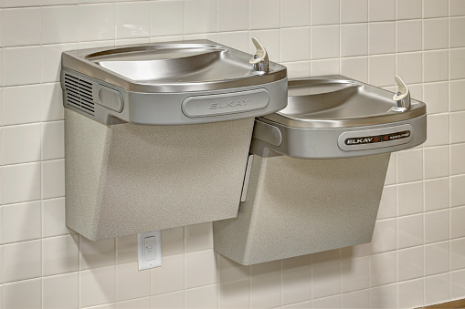 Two modern refrigerated drinking fountains.  One is a regulation height, and the other is ADA compliant height.
