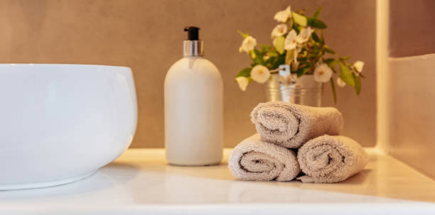 Bathroom interior detail. Clean hand towels roll ups, soap dispenser and sink basin on a table Bathroom towels roll ups, soap dispenser and white sink basin on a table, banner. Modern bathroom interior detail. roll up banner photos stock pictures, royalty-free photos & images