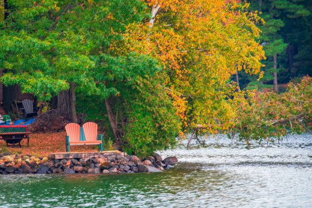 istock Adirondack chairs at the lake in autumn 1349212352