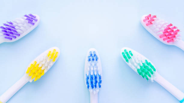 vue floue de cinq brosses à dents multicolores - toothbrush plastic multi colored hygiene photos et images de collection