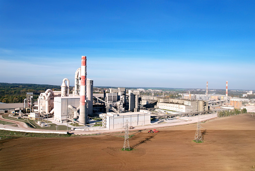 Cement plant with pipes. ement production process and Industrial solution. factory with smoke pipe. Chimney smokestack emission. Poor environment. Ecology concept, air and environmental pollution.