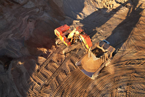 istock Mining excavator load the sand into dump truck in open pit. Developing the sand in the opencast. 1349214602