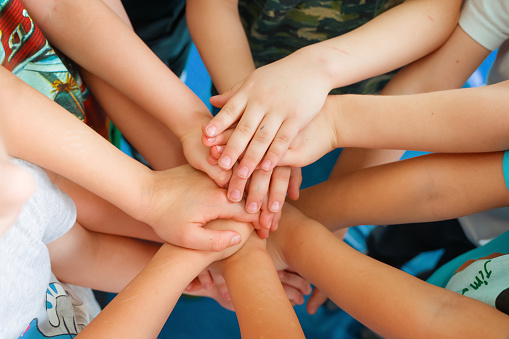 Team building. Children's hands. Group activity for children. The concept of achieving a common goal in a team
