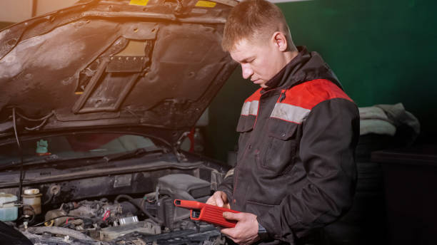 istock Worker uses digital device to check automobile at station 1349218082