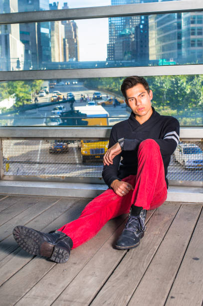 istock Young man sitting on floor by glass wall, relaxing, thinking 1349218476