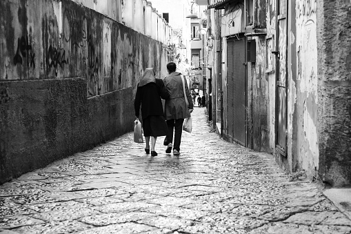 Naples, Italy, October 2021: Elderly nun walking arm in arm down the narrow streets of Naples, Italy.