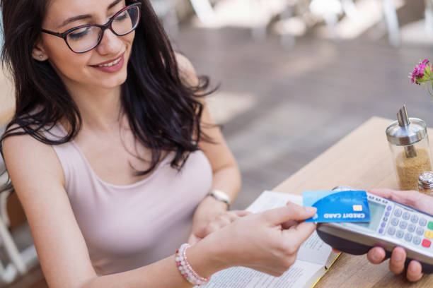 Cashless payment Young woman paying with credit card credit card paying banking business stock pictures, royalty-free photos & images