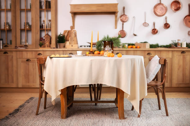 istock Interior design scandinavian kitchen with round table and chairs. Stylish dining room in rustic style. Cozy Wooden kitchen decorated Christmas or new year. On table fir branche in vase, Xmas cookies 1349221017