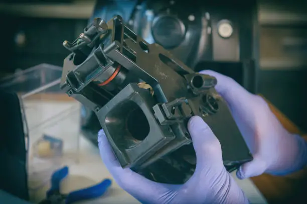 A repairman fixes a broken coffee maker, repair of household appliances