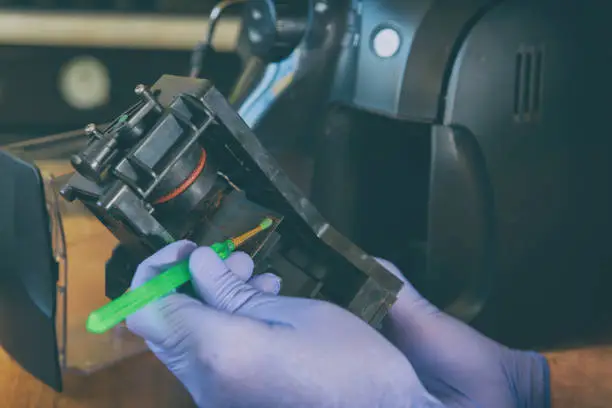 A repairman repairs a broken coffee maker with tool