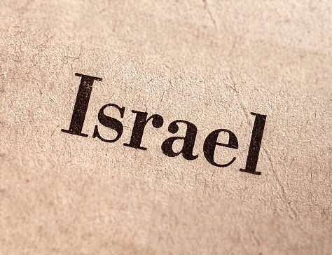Israel old newsprint newspaper style headline font with selective focus tilt shift beige background.