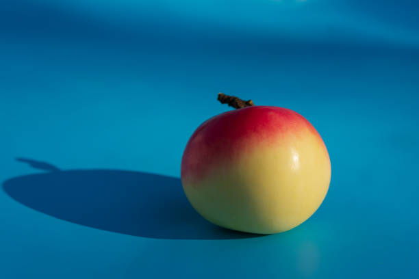 istock Red apple with white on blue background, closeup. 1349227845