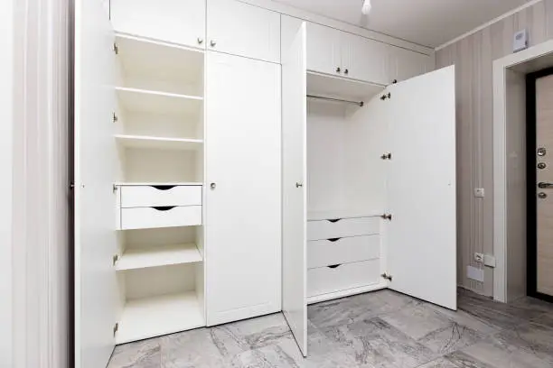 Photo of wardrobes with hinged doors on white door hinges, in the apartment