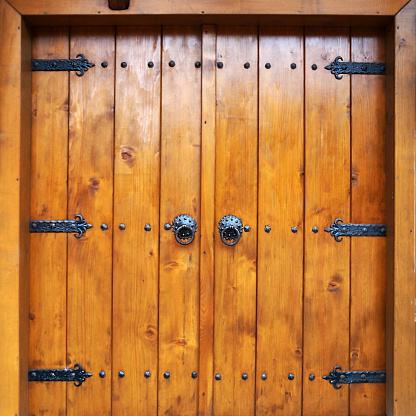 old double leaf wooden door with metal vintage hinges and handles.