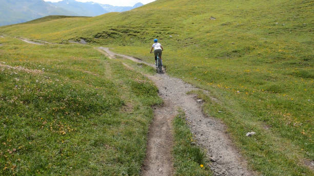 mountain biker segue trilha descendo ladeira de grama - davos switzerland summer mountain - fotografias e filmes do acervo